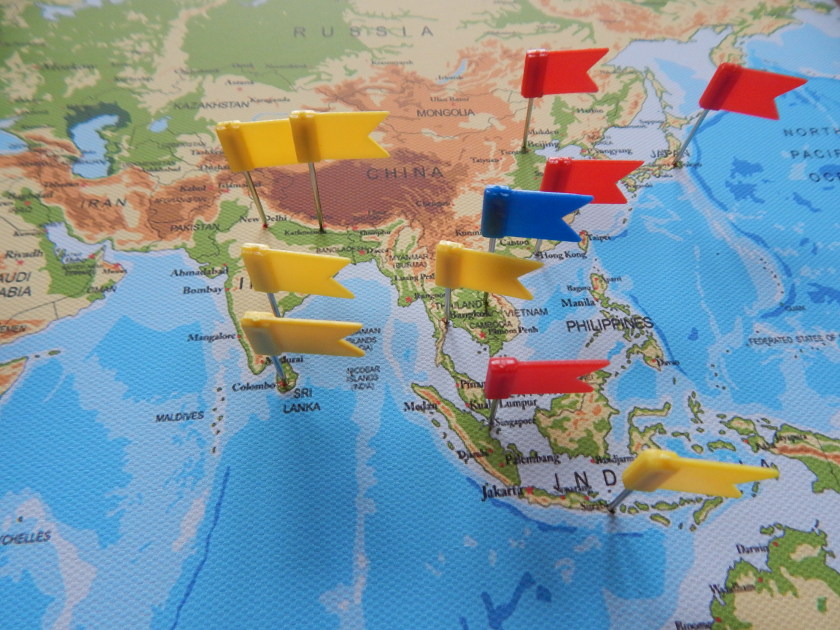 Weltkarte aus Leinwand mit bunten Flaggen zum Pinnen.